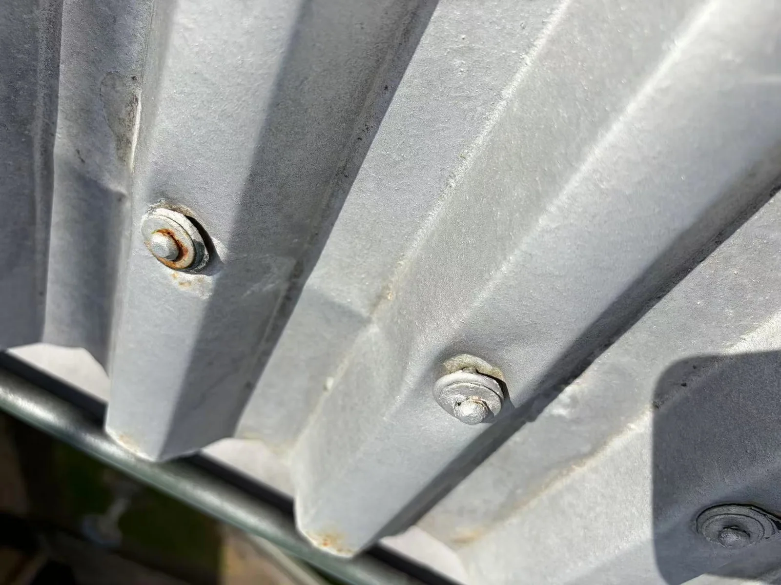 Adjacent fasteners across a profiled metal roof sheet