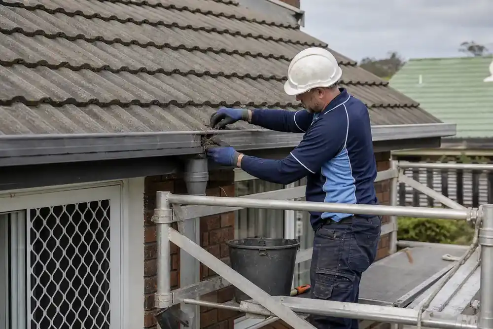 Simulated scene of a technician checking a gutter outlet from scaffold access